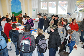 Das Bild zeigt eine Schulklasse beim Rundgang in der Malerwerkstatt