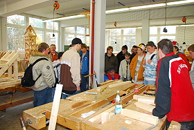 Das Bild zeigt eine Schulklasse beim Rundgang durch die Zimmererwerkstatt