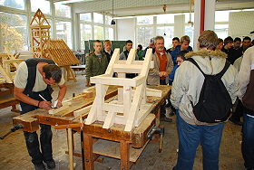 Das Bild zeigt eine Schulklasse beim Rundgang durch die Zimmererwerkstatt