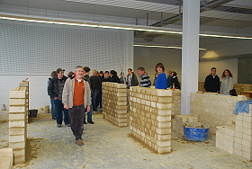 Das Bild zeigt eine Schulklasse beim Rundgang durch die Maurerwerkstatt.